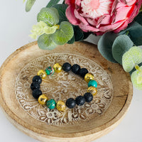 Black lava bead bracelet with gold & green beads